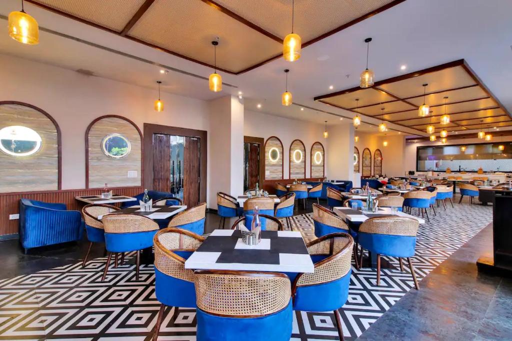 a restaurant with tables and chairs in a room at The Grand Anukampa Oasis in Jaipur lookinghotel.com