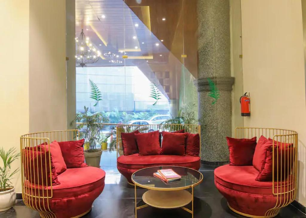 a lobby with two red chairs and a table at The Grand Anukampa Oasis in Jaipur