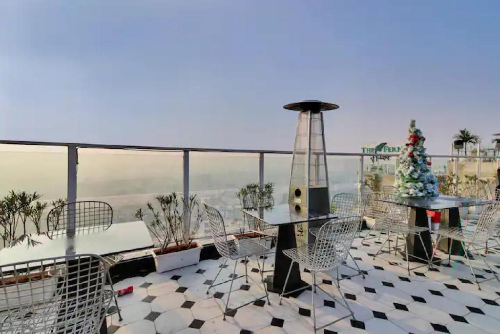 a balcony with a christmas tree and tables and chairs at The Grand Anukampa Oasis in Jaipur
