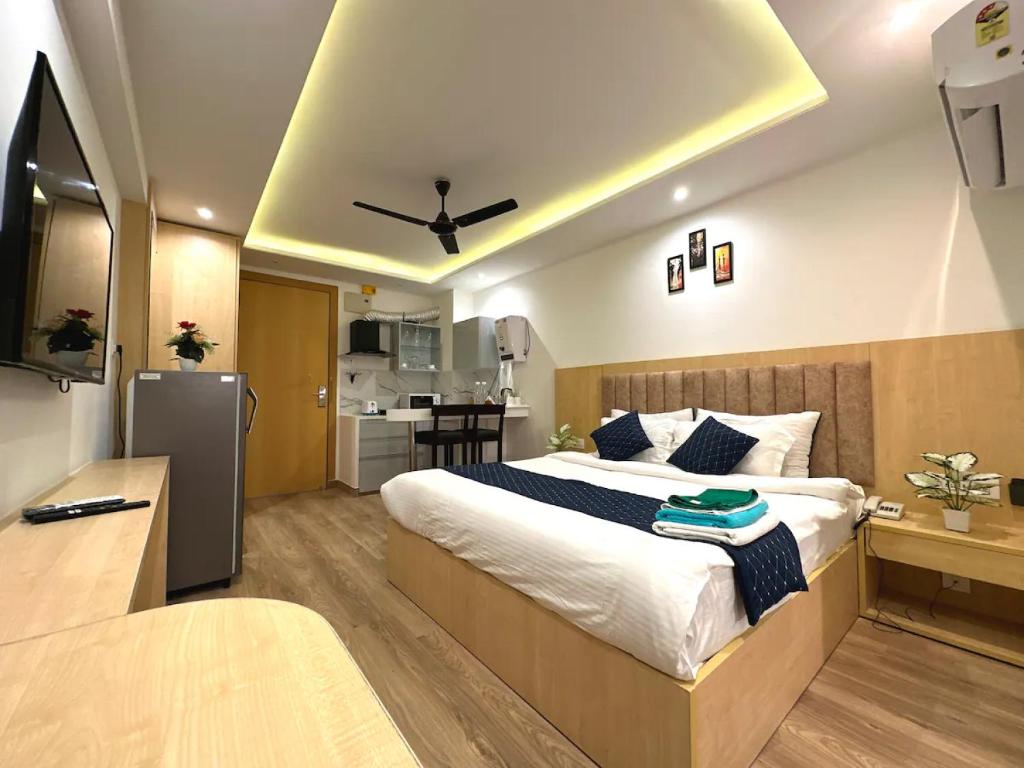 a bedroom with a large bed and a kitchen at The Grand Anukampa Oasis in Jaipur
