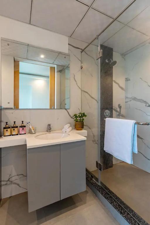 a bathroom with a sink and a shower at The Grand Anukampa Oasis in Jaipur lookinghotel.com