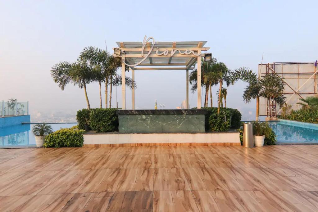 a wooden floor on top of a building with palm trees at The Grand Anukampa Oasis in Jaipur lookinghotel.com