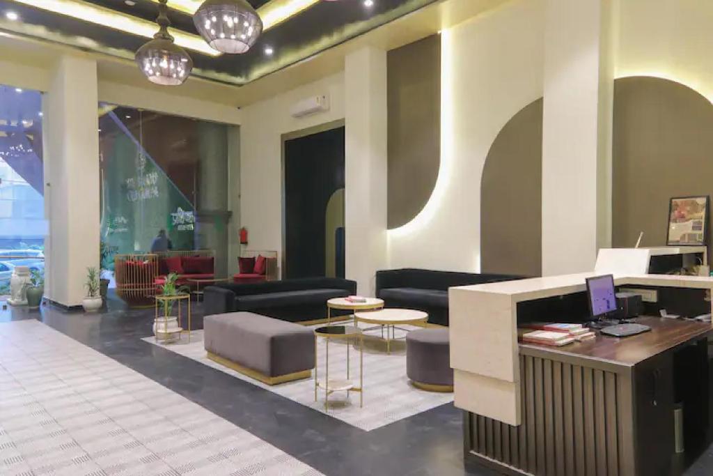 a lobby with couches and a desk with a computer at The Grand Anukampa Oasis in Jaipur