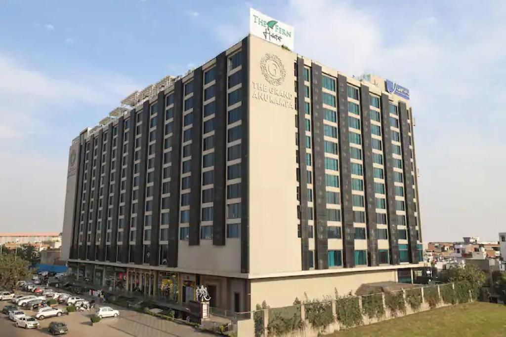 a large building with a sign on top of it at The Grand Anukampa Oasis in Jaipur lookinghotel.com