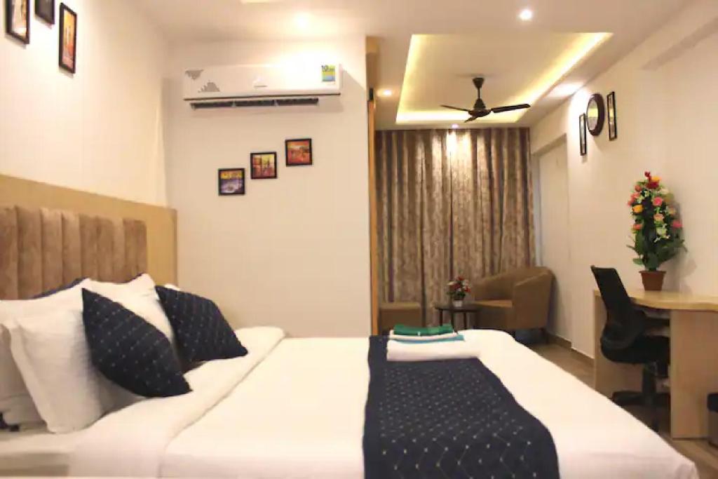 a bedroom with a white bed with black and white pillows at The Grand Anukampa Oasis in Jaipur lookinghotel.com