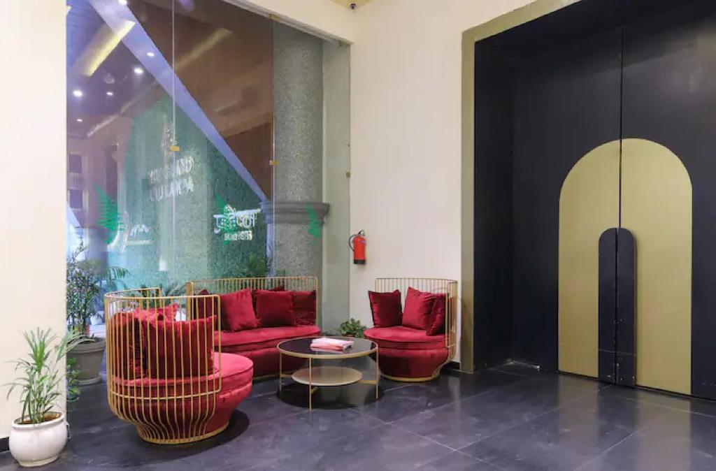 a lobby with red chairs and a table at The Grand Anukampa Oasis in Jaipur