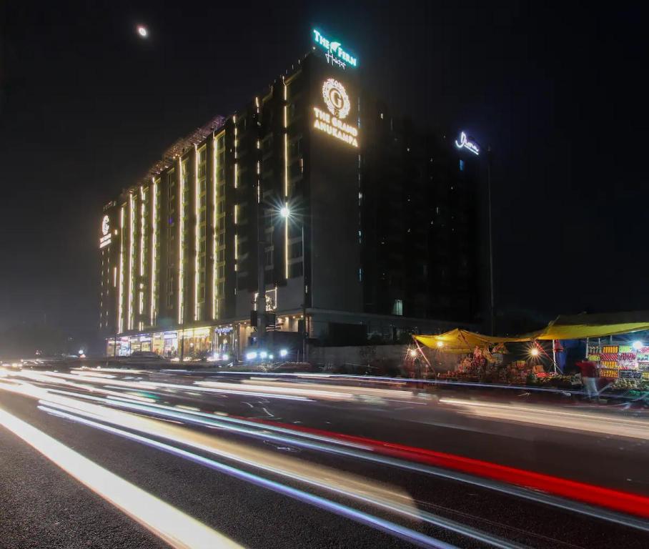 a building with a clock on it at night at The Grand Anukampa Oasis in Jaipur