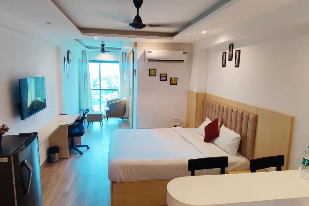 a hotel room with a bed and a desk and a room at The Grand Anukampa Oasis in Jaipur lookinghotel.com