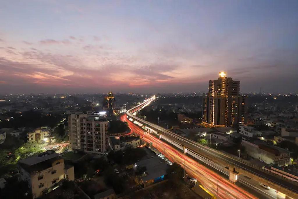 a city lit up at night with traffic on a highway at The Grand Anukampa Oasis in Jaipur