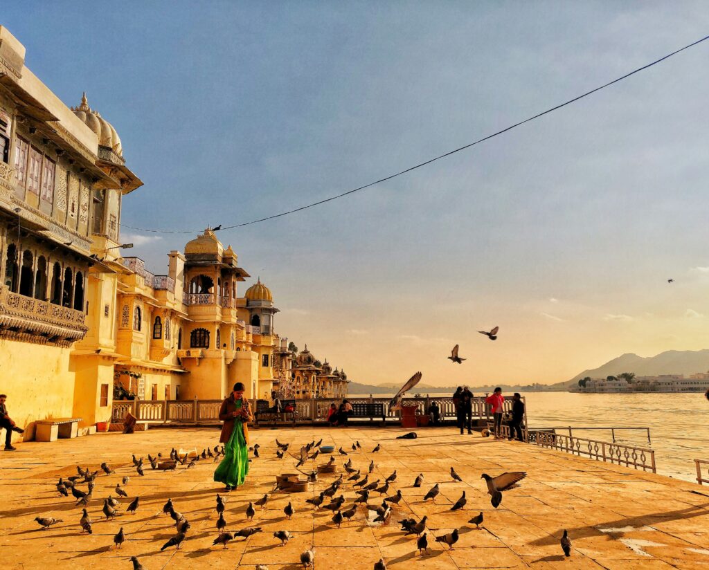 City Palace Udaipur illuminated at sunset overlooking Lake Pichola